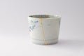 Antique blue and white cup repaired with the antique kintsugi real gold technique Royalty Free Stock Photo
