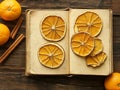 An antique book is positioned on a distressed wooden background, alongside cinnamon, oranges, and a selection of spices Royalty Free Stock Photo