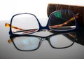 Antique book and reading glasses on a reflective surface. Royalty Free Stock Photo