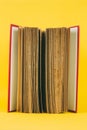 Antique book with worn out pages with red spine on yellow background Royalty Free Stock Photo