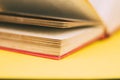 Antique book with worn out pages with red spine on yellow background Royalty Free Stock Photo