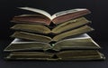 Old books with leather covers and red and gold yellow pages. Placed in pile on a dark background Royalty Free Stock Photo