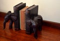 Antique books, wooden elephant bookends on wood table