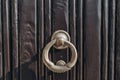 Antique brass door knocker in the shape, door element with metal knob. A old door handle on a vintage wooden black door Royalty Free Stock Photo