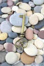 Antique Brass key on a pebble beach