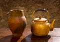 Antique brass teapot on retro wood table and clay jar Royalty Free Stock Photo