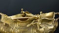 Antique bronze bowl with ornate patterns and an angel figure close-up