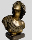 Antique bronze bust of a young woman on a light blue background.