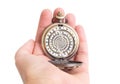 Antique bronze watch with a distorted watch face in a female`s hand isolated on white