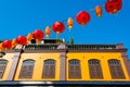 Antique brown wooden window Colonial style architecture building on yellow cement wall and paper red lantern with blue sky  Chines Royalty Free Stock Photo