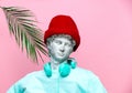 Antique bust of male in hat with headphones on pink background.