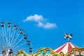 Antique carousel horses tent in amusement park with colourful ferris wheel