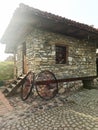 antique carriage wheels, leaning against the wall of a stone, old, country house