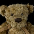 Vintage teddy bear toy on isolated black background