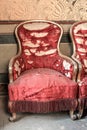 Antique armchairs in pure gold and torn red silk