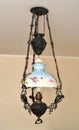 Antique chandelier with iron construction and lampshade with floral motif