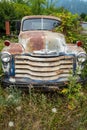 An antique Chevy truck overgrown with weeds in a junkyard in Idaho, USA - July 26,2021 Royalty Free Stock Photo