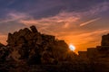 Antique city ruins under sunset with scattered clouds