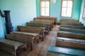 Antique classroom with empty wooden desks and benches