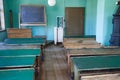 Antique classroom with empty wooden desks and benches