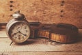 Antique clock and old violin over vintage wooden table Royalty Free Stock Photo