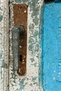 Antique closed door with metal door handle and vibrant white-blu paint