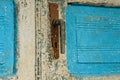 Antique closed door with metal door handle and vibrant white-blu paint