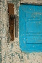 Antique closed door with metal door handle and vibrant white-blu paint