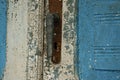 Antique closed door with metal door handle and vibrant white-blu paint