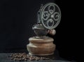 Antique coffee bean original grinder metal shake wheel with hand crank and coffee beans on dark background Royalty Free Stock Photo