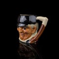 Antique coffee cup in the shape of a man`s head on a black background.