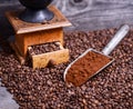 Antique coffee grinder with grinded coffee in scoop on beans Royalty Free Stock Photo