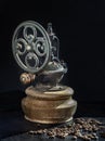 Antique coffee original grinder metal shake wheel with hand crank and coffee beans on dark background Royalty Free Stock Photo