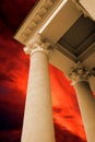 The antique columns on the red sky background