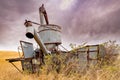 Antique combine rusting in a farmers field with bullet holes in it