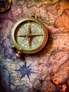 An antique compass placed on a vintage map Royalty Free Stock Photo