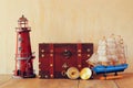 Antique compass, vintage lighthouse, wooden boat and old chest on wooden table Royalty Free Stock Photo