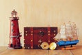 Antique compass, vintage lighthouse, wooden boat and old chest on wooden table