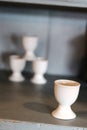 Antique cream egg cups on shelf of old kitchen display cabinet