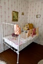 Antique crib, Teddy, Bear,, Pictures and a doll are part of a museum room setting.