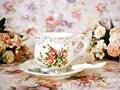 Antique cup of tea with saucer ,yellow orange rose flowers background ,porcelain vintage style ,old English coffee cup still life Royalty Free Stock Photo