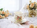 Antique cup of tea with yellow orange rose flowers background ,porcelain teacup vintage style ,old English coffee cup Royalty Free Stock Photo