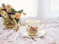 Antique cup of tea with yellow orange rose flowers background ,porcelain teacup vintage style ,old English coffee cup Royalty Free Stock Photo