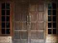 Antique, dark brown door gate in front of old house Royalty Free Stock Photo