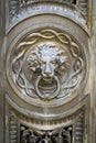 Antique decorative handle knocker on wooden vintage house door. Classical metal bronze lion head