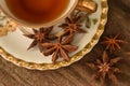 Antique cup with star anise tea on rustic background Royalty Free Stock Photo