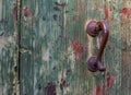 Antique door handle and wooden door. The paint on the door cracked and peeled off. Royalty Free Stock Photo