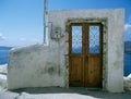 Antique door in isolated wall down to the mediterranean