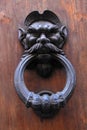 Antique door knob with man's head on old wooden obsolete door Royalty Free Stock Photo