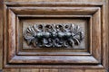 An antique door knob in the shape of a dog head on a wooden door. Royalty Free Stock Photo